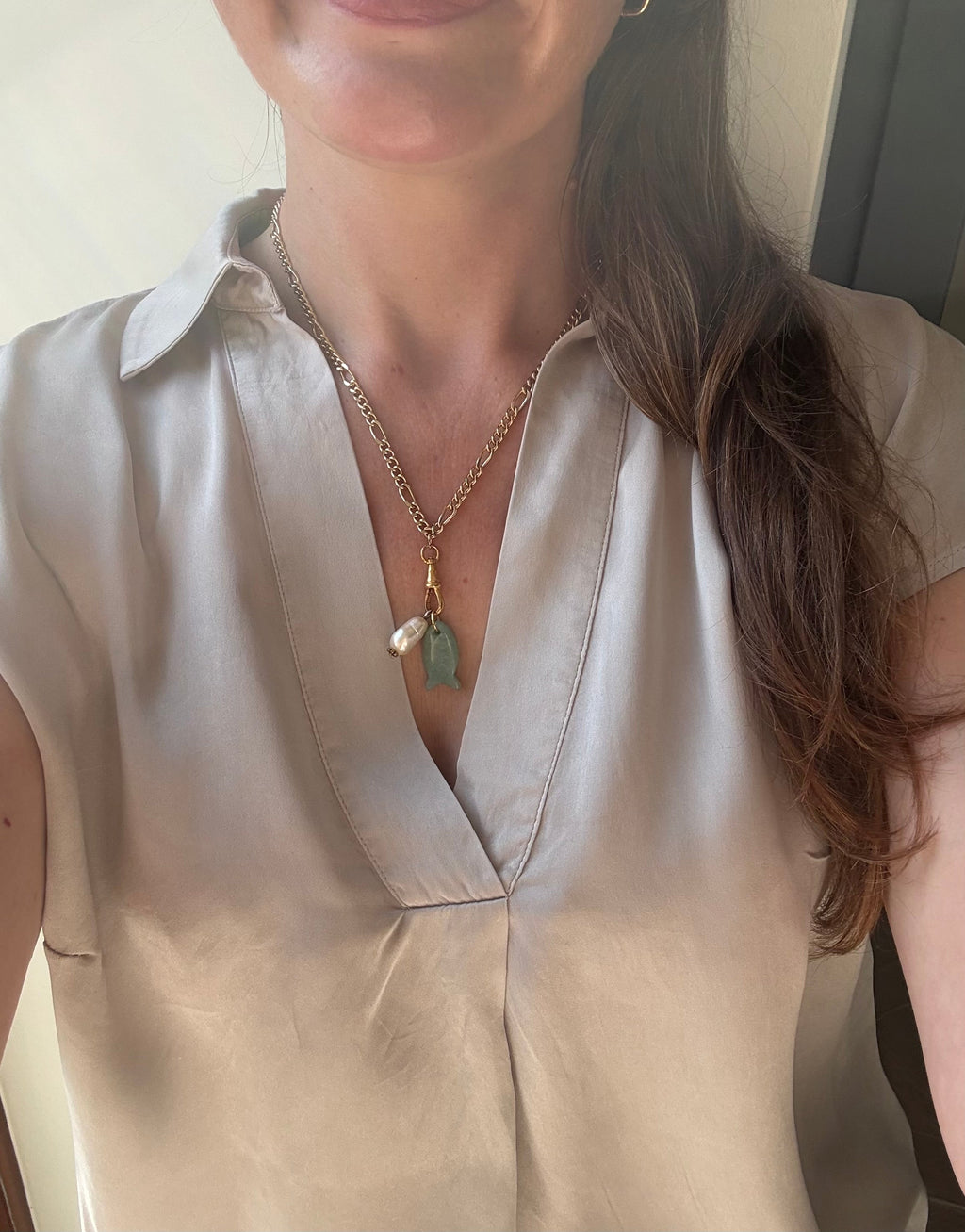 Gold figaro chain necklace with jade fish and baroque pearl worn