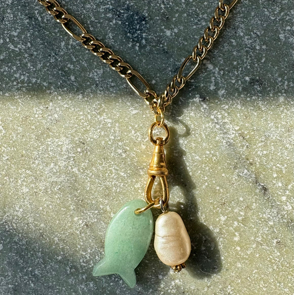 Jade fish charm and baroque pearl close up