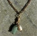 Jade fish and baroque pearl charm detail in sunlight