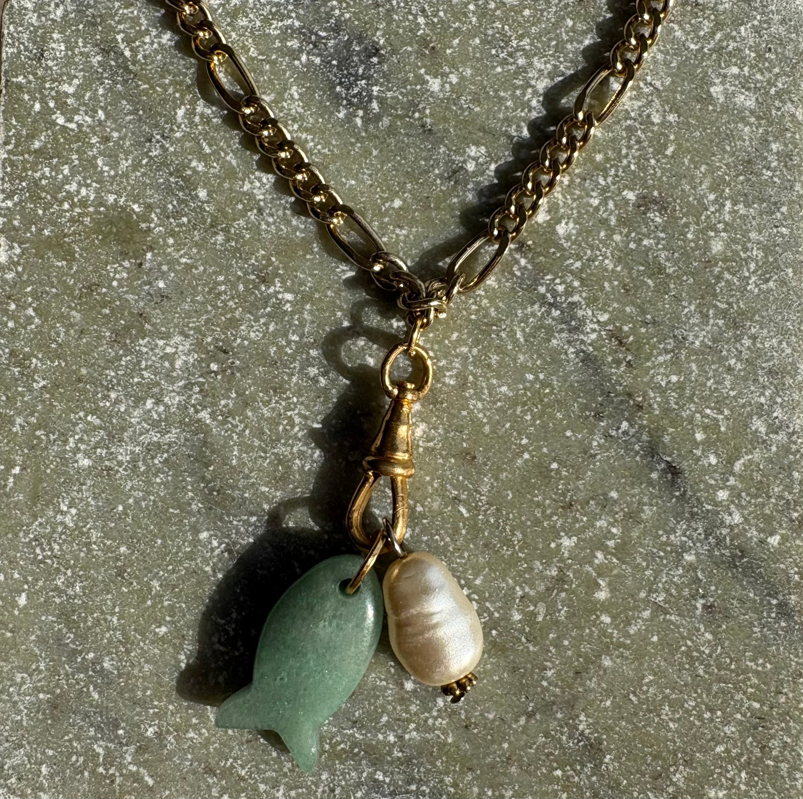 Jade fish and baroque pearl charm detail in sunlight