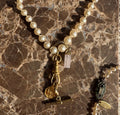 Vintage pearl necklace with gold charms on marble - detail